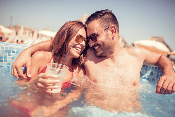 美しいカップル スイミング プールでカクテルを飲んで - 写真・画像