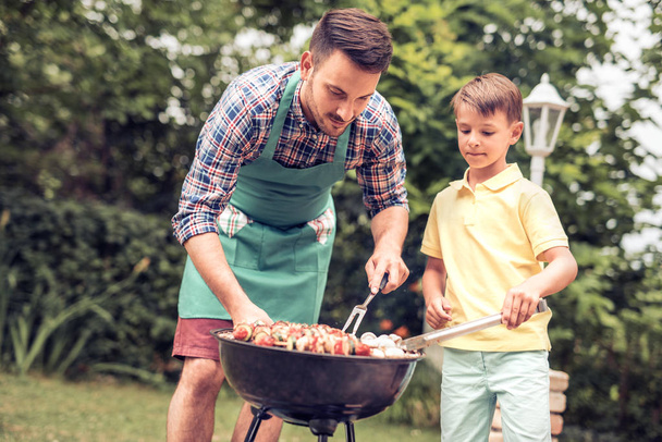 Father and son having a barbecue party - 写真・画像
