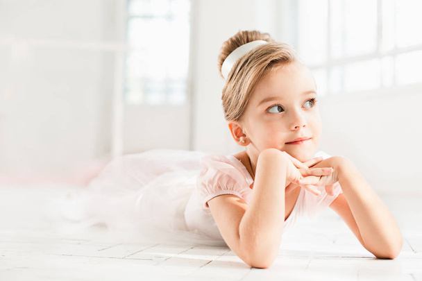 The little balerina in white tutu in class at the ballet school - Foto, afbeelding