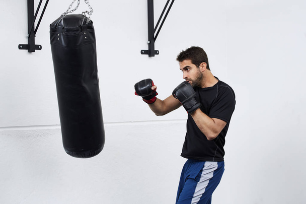 Guy boxing with punch bag - Φωτογραφία, εικόνα