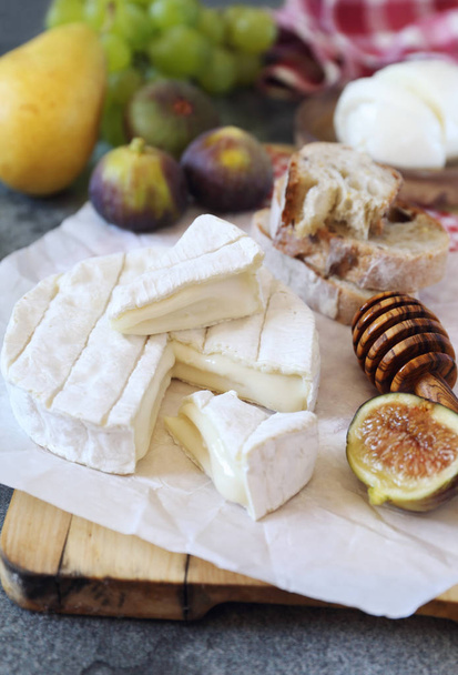 Cheese plate: goat cheese, fruits, mozzarella and bread - Photo, Image