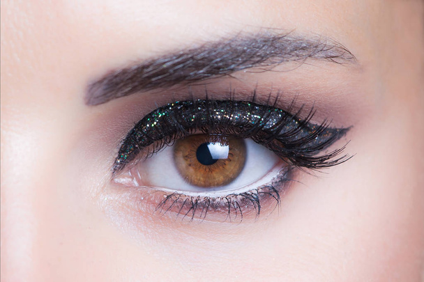 olho de mulher com brilho noite maquiagem closeup estúdio
 - Foto, Imagem
