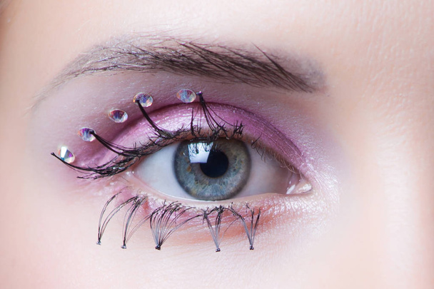 женский глаз с кристаллами и розовым макияжем тени для век
 - Фото, изображение
