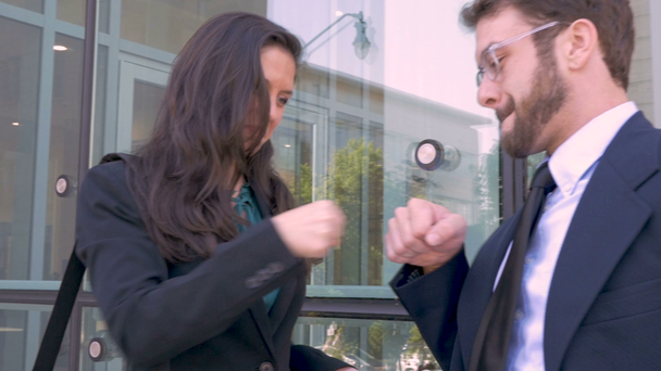 Dos ejecutivos de negocios celebran el éxito con un puñetazo fuera de la oficina
 - Imágenes, Vídeo