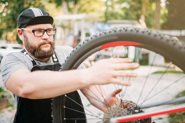 service man working with bike wheel - Fotografie, Obrázek