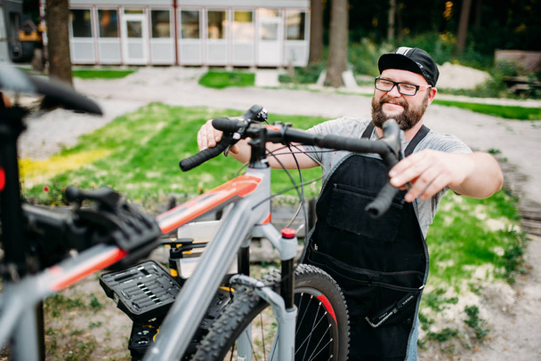 mecánico masculino reparación de bicicleta
  - Foto, Imagen
