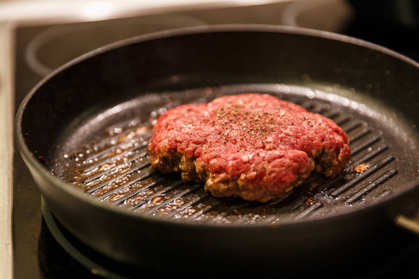 Ground meat patty in a frying pan - Foto, imagen