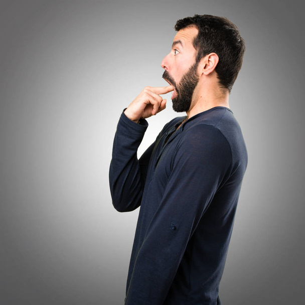 Красавчик с бородой делает рвотный жест серой заднице
 - Фото, изображение