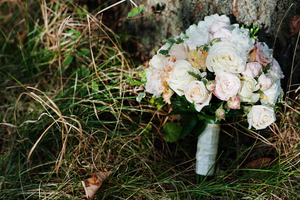Close-up photo of a wedding bouquet laying in the grass. - Foto, Bild