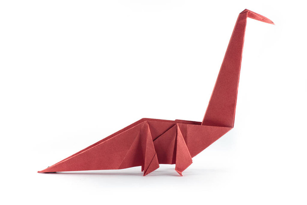 Origami dinosaurus raptor geïsoleerd op witte achtergrond - Foto, afbeelding