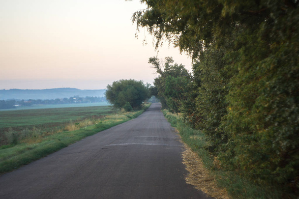 Paysage du matin près de la route en arrière-plan du village
. - Photo, image
