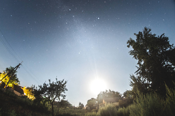 Έναστρο ουρανό το βράδυ το καλοκαίρι πάνω από το χωριό. - Φωτογραφία, εικόνα