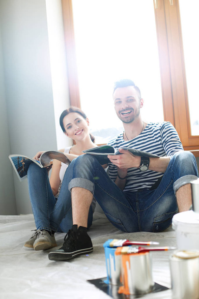 Portrait happy smiling young couple painting interior wall of new house. Young couple - Foto, Bild