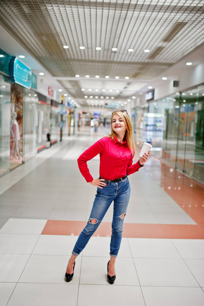 Portrait of a gorgeous woman in red blouse and jeans holding a c - Foto, Imagem