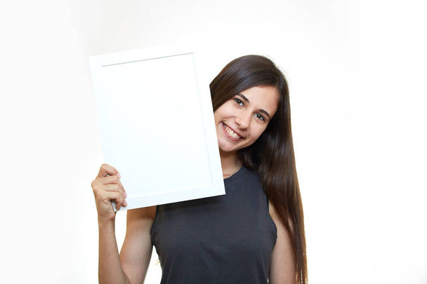The girl is holding a poster. White background. Emotions - Фото, зображення