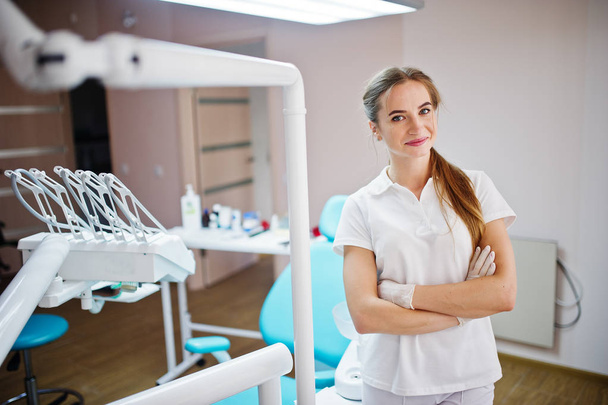 Good-looking female dentist posing in white coat in a modern wel - Photo, image