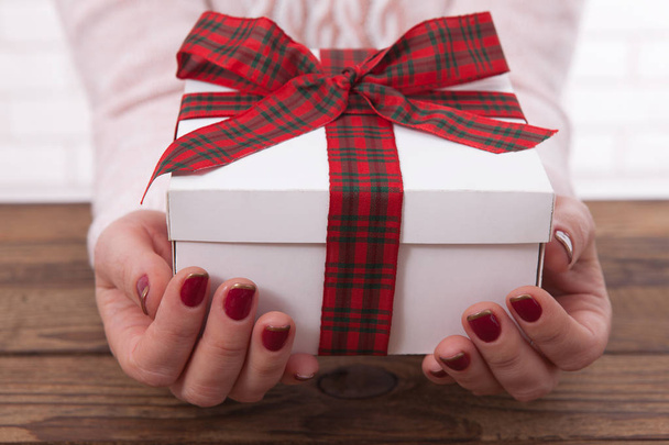 Woman holding presents gift box laid on wooden table background - Foto, Imagem
