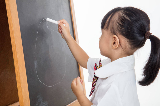 Asian Chinese little girl drawing on blackboard - 写真・画像