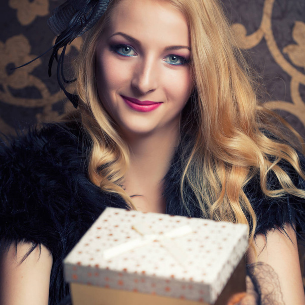 woman holding a golden gift boxes - Foto, Bild