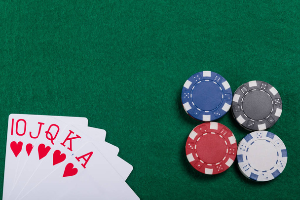 Game chips and cards on the green poker table. A winning combination in Royal Flush poker - Foto, Imagen