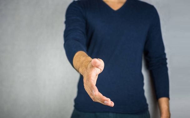 απλώσεις το χέρι από τον άνθρωπο, σε ανοιχτό γκρίζο φόντο - Φωτογραφία, εικόνα