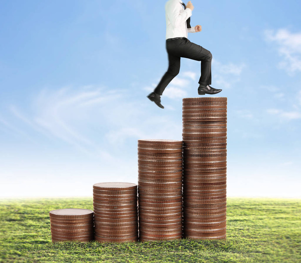 Empresario caminar en pila de monedas que crece el éxito
  - Foto, Imagen