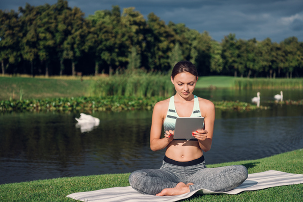 Frau praktiziert Yoga mit Tablet - Foto, Bild