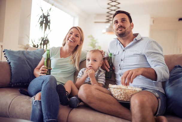 Szczęśliwa rodzina ogląda telewizję na kanapie w domu - Zdjęcie, obraz
