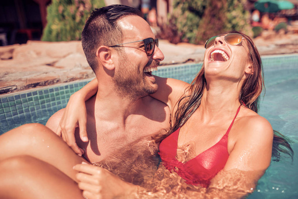 Couple relaxing in swimming pool - Foto, afbeelding
