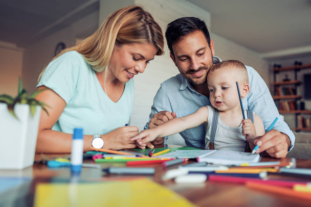Sonriente familia dibujando juntos en casa
 - Foto, imagen