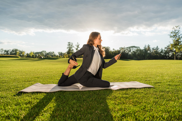 businesswoman practicing yoga with tablet - Photo, Image