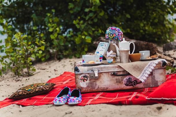 Bir plaj romantik natürmort piknik. Bardak, çerez, bavul - Fotoğraf, Görsel