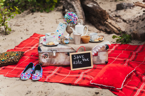 Martwa natura romantyczny piknik na plaży. Kubki, cookie, walizka - Zdjęcie, obraz
