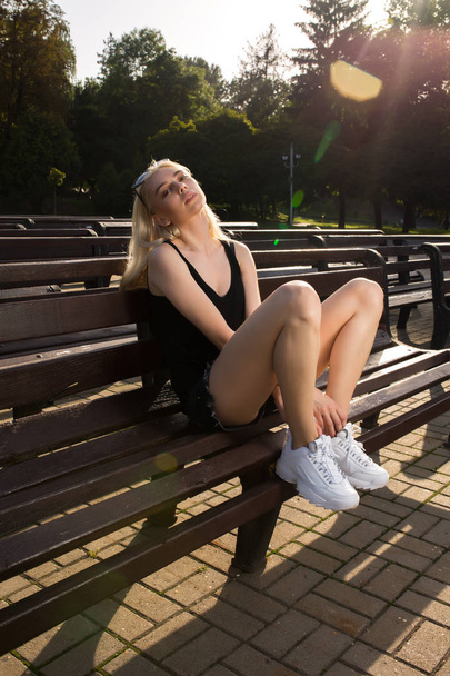 Beautiful blonde model in casual clothes and white sneakers posi - Fotoğraf, Görsel