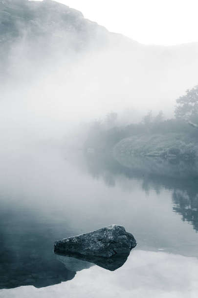 A beautiful mountain lake in a fog in Tatry, Slovakia. Low saturation retro style - Foto, Imagen