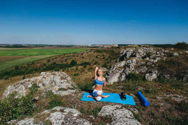  woman doing yoga on a rock - Φωτογραφία, εικόνα