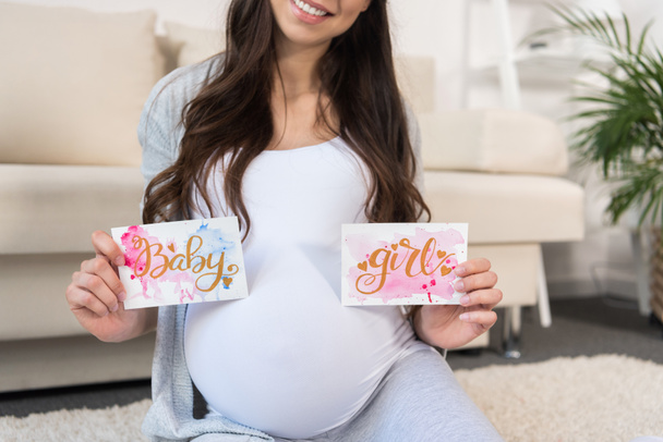 Pregnant woman holding greeting cards - Foto, Imagen