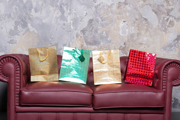 Sofa with colorful present bags - Foto, afbeelding