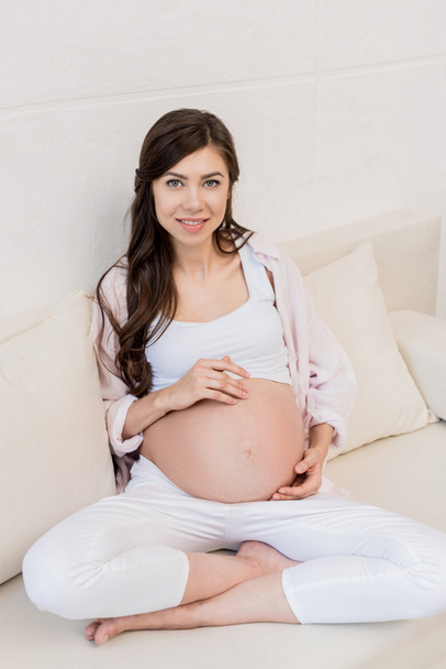 Femme enceinte touchant son ventre   - Photo, image