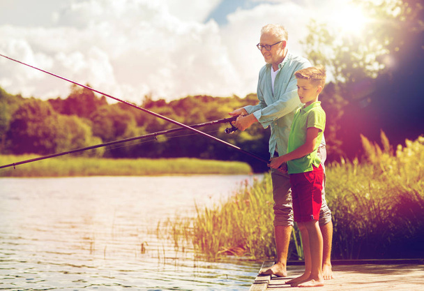 grandfather and grandson fishing on river berth - Foto, Imagen