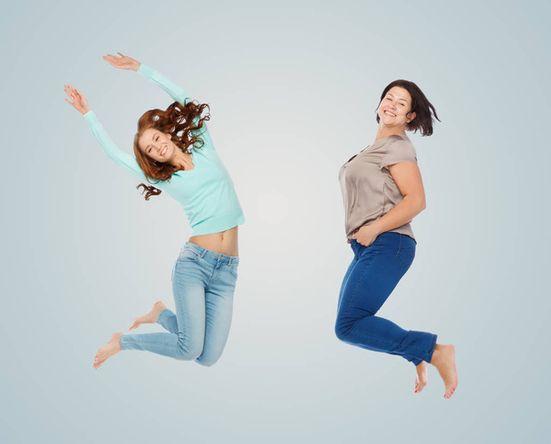 happy different women jumping over blue - Фото, изображение