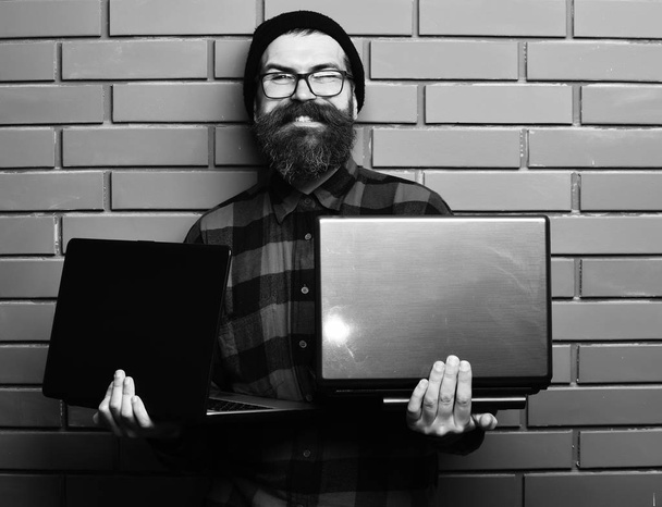 Bearded brutal caucasian hipster holding laptops - Foto, imagen
