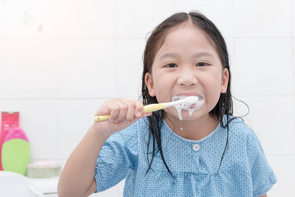 boldog ázsiai aranyos lány fogmosás a bathroon  - Fotó, kép