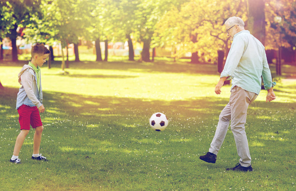 Alter Mann und Junge spielen Fußball im Sommerpark - Foto, Bild