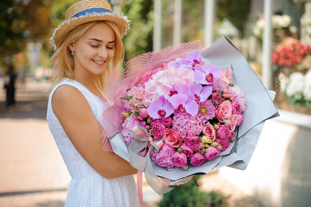 A girl in a hat holds a fashionable bouquet - Foto, Imagem