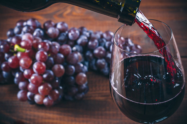 Pouring red wine into the glass  - Zdjęcie, obraz