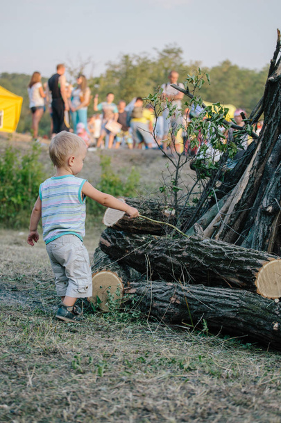 Portrait de mignon petit garçon à l'extérieur sur le fond de bois de chauffage empilé
 - Photo, image