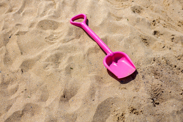 Розовый песок игрушка на пляже. День отпуска
 - Фото, изображение