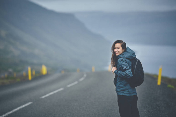 a woman tourist on the empty road on the fjord in Iceland - Φωτογραφία, εικόνα