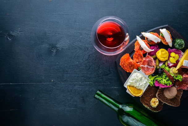 Set snacks with meat and pickled vegetables. Italian cuisine. Top view. On Wooden background. - 写真・画像